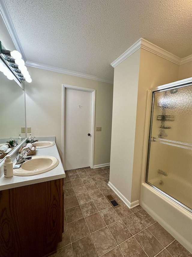 bathroom featuring visible vents, double vanity, crown molding, a textured ceiling, and enclosed tub / shower combo