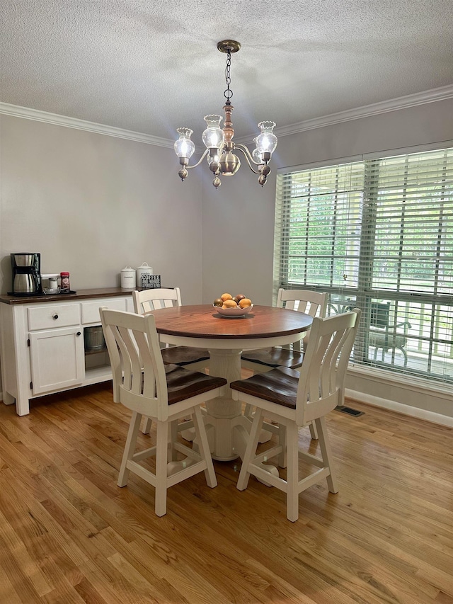dining space featuring crown molding, plenty of natural light, and a chandelier