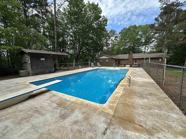 view of swimming pool with fence, an outdoor structure, a patio area, and a fenced in pool