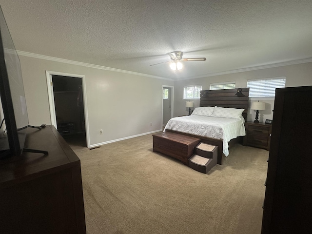 bedroom featuring a textured ceiling, carpet, a ceiling fan, baseboards, and ornamental molding
