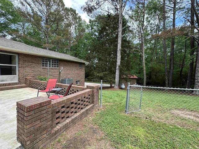view of yard featuring fence, central AC unit, and a patio area