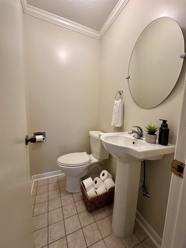 half bathroom featuring tile patterned floors, ornamental molding, toilet, and a textured ceiling