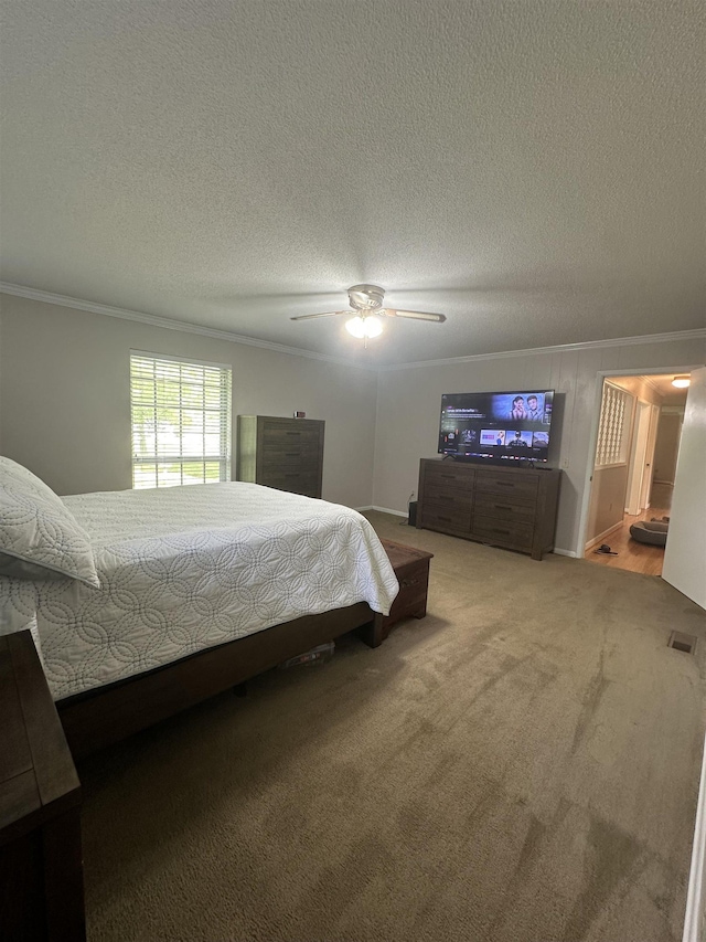 bedroom featuring crown molding, a ceiling fan, visible vents, a textured ceiling, and carpet flooring