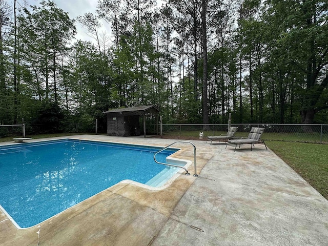 view of pool featuring fence, a fenced in pool, a patio area, a gazebo, and a diving board