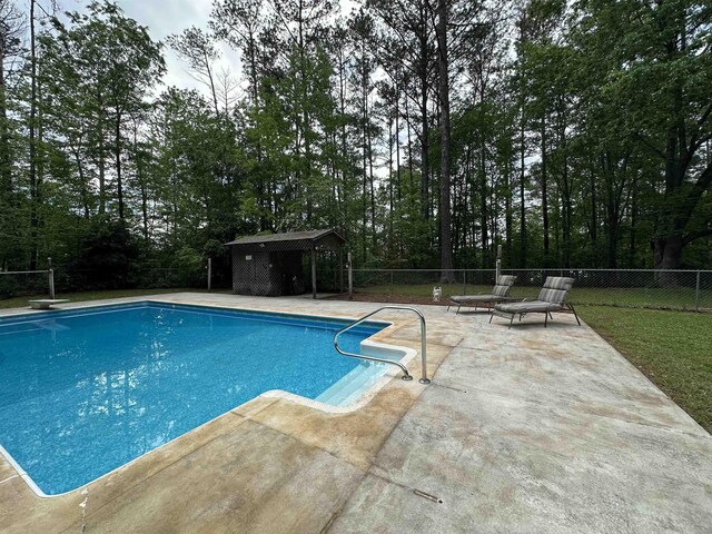  - view of pool featuring fence, a fenced in pool, a patio area, a gazebo, and a diving board