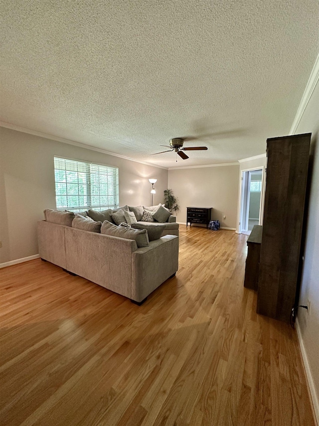 living room featuring light wood-style floors, crown molding, a textured ceiling, and ceiling fan