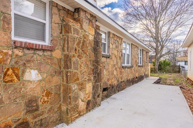 view of side of home featuring a patio, fence, and crawl space