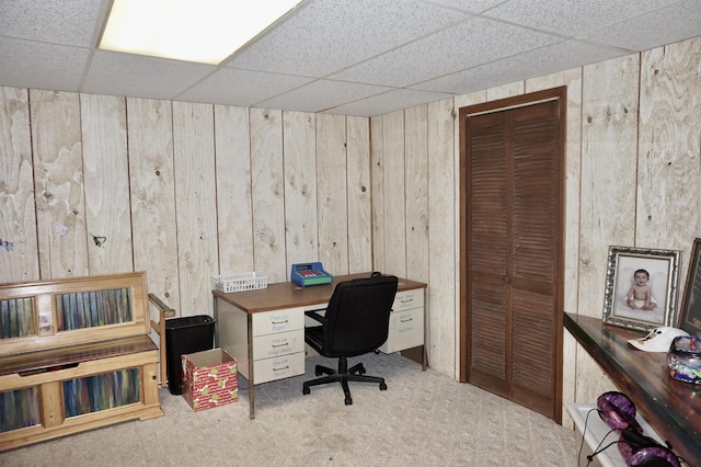 office featuring carpet flooring, a drop ceiling, and wooden walls