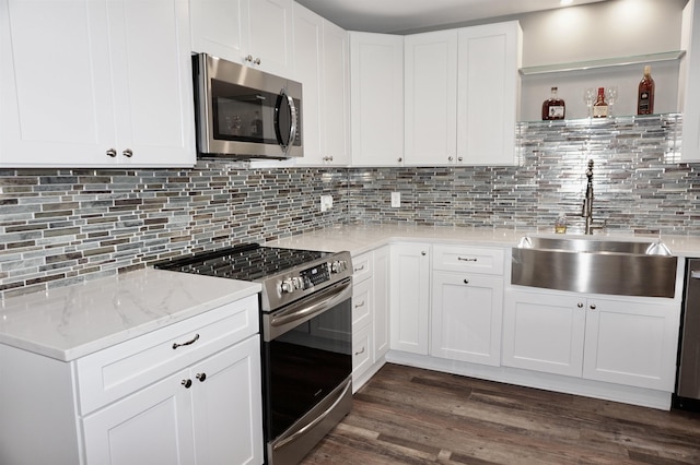 kitchen featuring sink, stainless steel appliances, dark hardwood / wood-style floors, decorative backsplash, and white cabinets