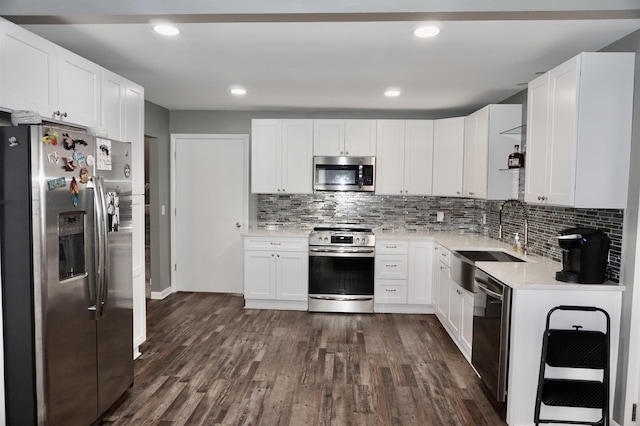 kitchen featuring white cabinetry, sink, dark wood-type flooring, stainless steel appliances, and tasteful backsplash