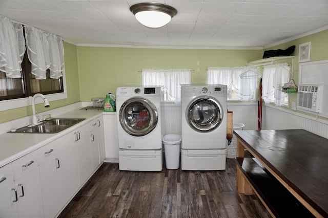 clothes washing area with dark hardwood / wood-style floors, cooling unit, washing machine and dryer, and sink