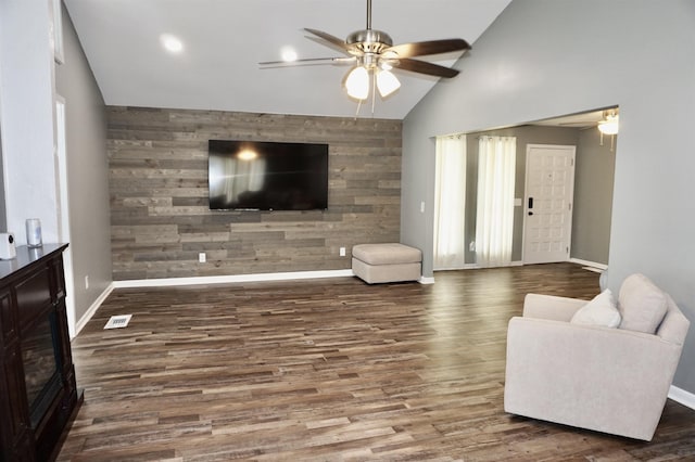 living room with ceiling fan, dark hardwood / wood-style flooring, and lofted ceiling