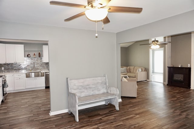 sitting room with dark hardwood / wood-style flooring, ceiling fan, and sink