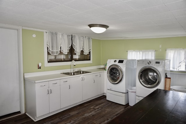 laundry room with washer and dryer, dark hardwood / wood-style flooring, cabinets, and sink