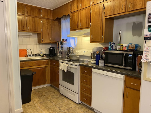  - kitchen with white appliances, under cabinet range hood, brown cabinets, decorative backsplash, and a textured ceiling