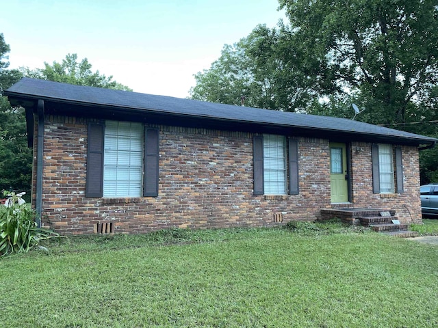 - ranch-style house featuring brick siding, a front yard, and a shingled roof