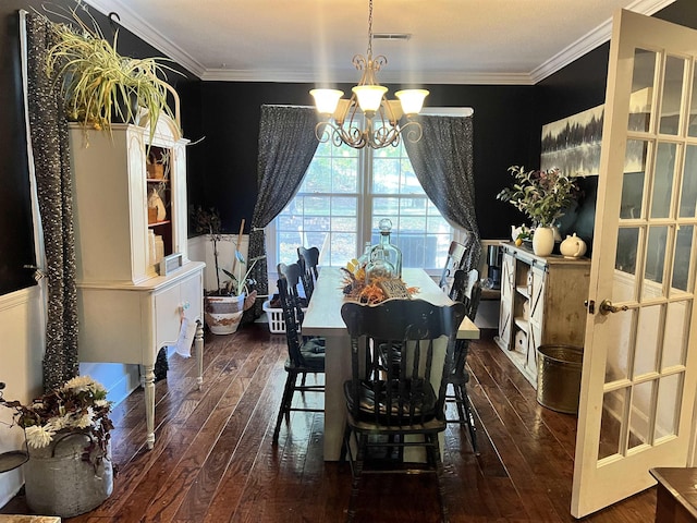  - dining area with crown molding, dark hardwood / wood-style floors, and an inviting chandelier