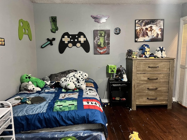  - bedroom featuring a textured ceiling and dark hardwood / wood-style flooring