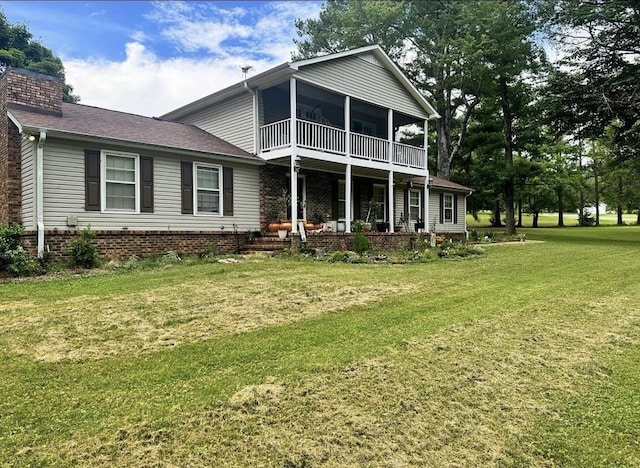 rear view of property featuring a yard and a sunroom