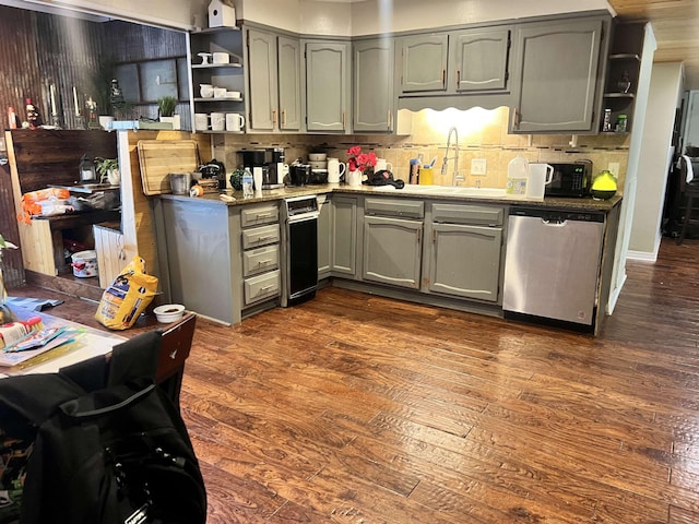  - kitchen featuring decorative backsplash, dark hardwood / wood-style floors, stainless steel dishwasher, and sink