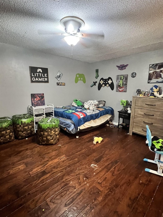  - bedroom with ceiling fan, dark hardwood / wood-style flooring, and a textured ceiling
