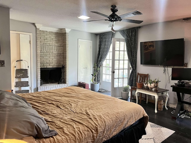  - bedroom featuring ceiling fan, a fireplace, dark hardwood / wood-style floors, and a textured ceiling