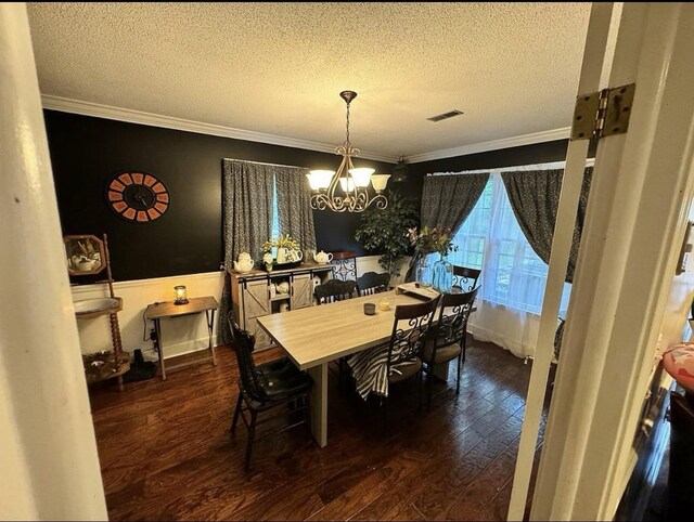  - dining space featuring a chandelier, dark hardwood / wood-style flooring, a textured ceiling, and crown molding