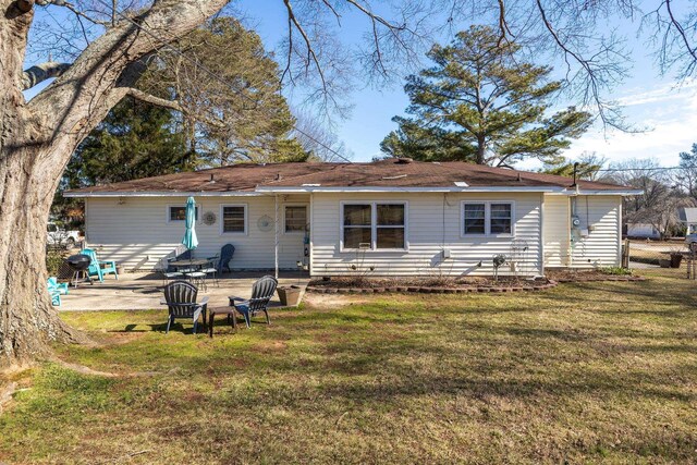 back of property featuring a patio and a lawn