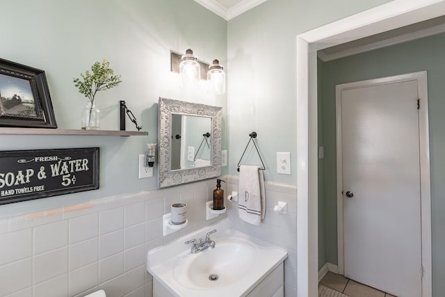 half bathroom with tile walls, vanity, and crown molding