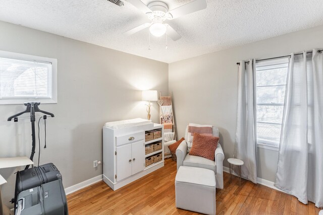 sitting room featuring baseboards, plenty of natural light, and light wood finished floors