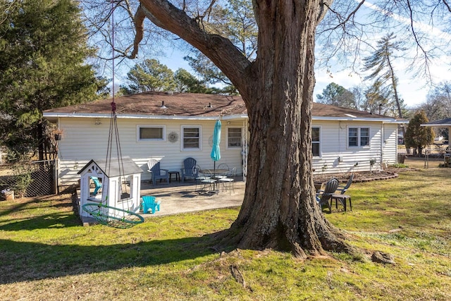 rear view of house featuring a patio area, a yard, and fence