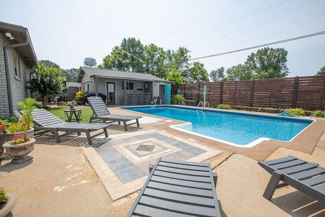  - view of swimming pool featuring a patio, a fenced backyard, an outbuilding, and an exterior structure