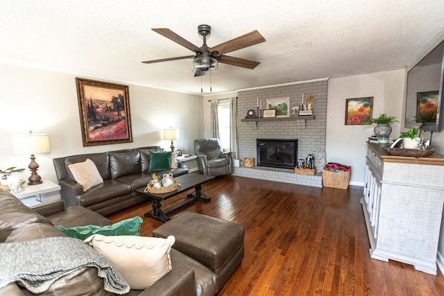  - living area with a ceiling fan, a brick fireplace, wood finished floors, and a textured ceiling