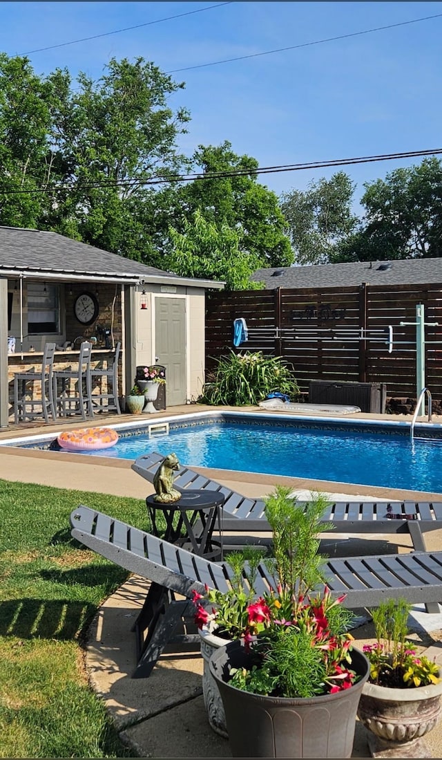  - outdoor pool featuring an outbuilding