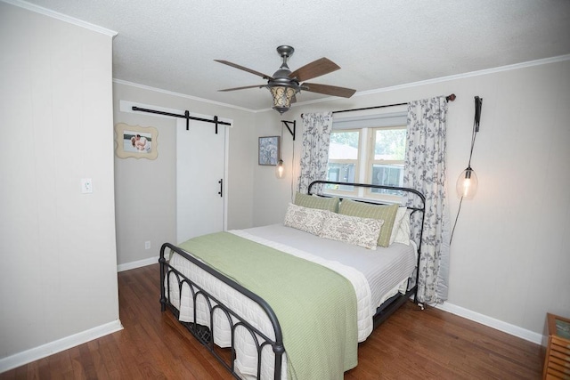 - bedroom with a barn door, wood finished floors, ornamental molding, ceiling fan, and a textured ceiling