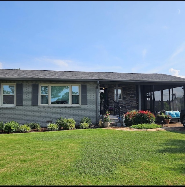 - view of front of house with a front lawn, brick siding, and a shingled roof