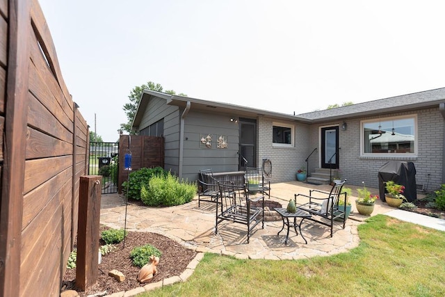  - back of property featuring entry steps, brick siding, a patio area, and a gate