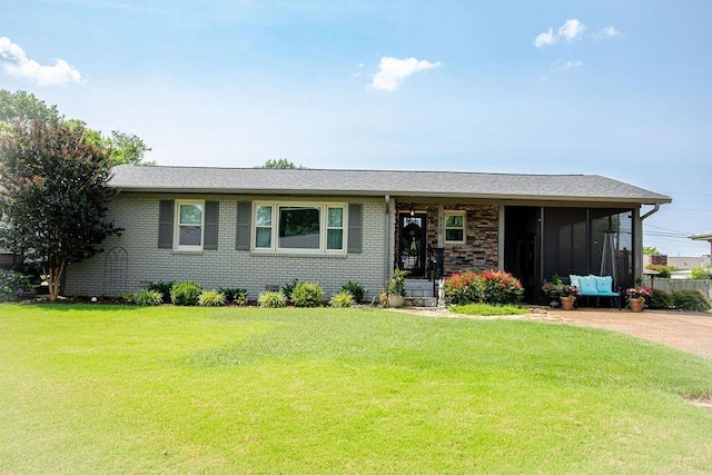  - view of front facade with a sunroom, a front yard, and brick siding