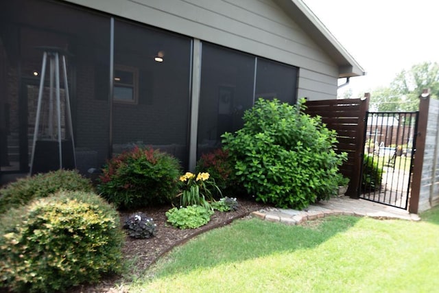  - view of side of property with a gate and a sunroom