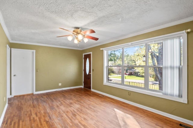 unfurnished room with hardwood / wood-style floors, ceiling fan, and crown molding