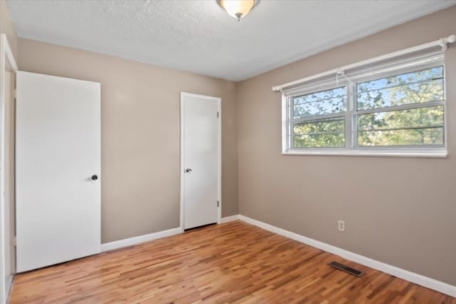 unfurnished bedroom featuring a closet and light wood-type flooring