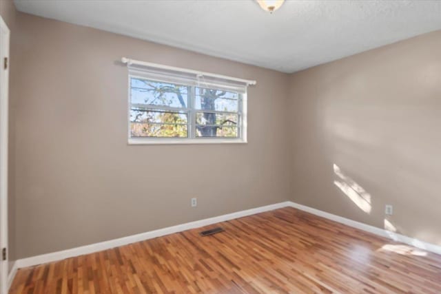 empty room with hardwood / wood-style floors