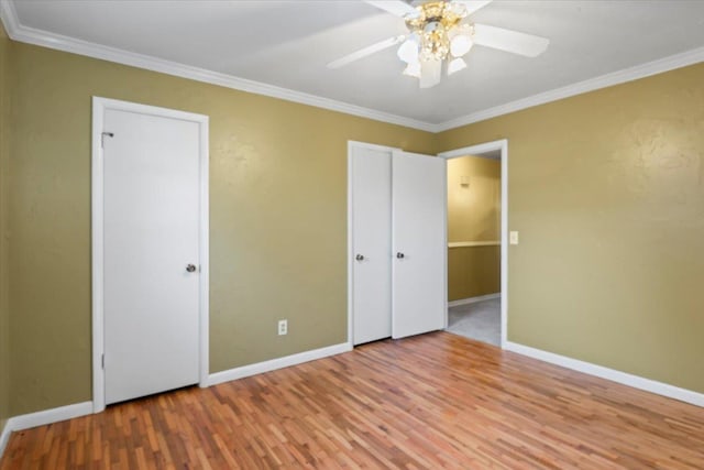 unfurnished bedroom with ceiling fan, a closet, wood-type flooring, and ornamental molding