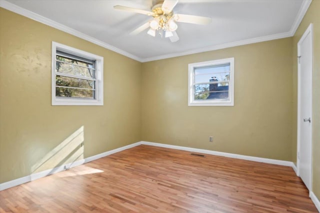 unfurnished room with hardwood / wood-style floors, a healthy amount of sunlight, and crown molding