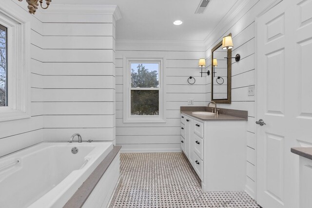 bathroom with vanity, a bathtub, crown molding, and wooden walls