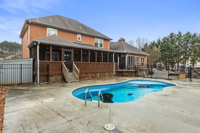 view of swimming pool with a sunroom and a patio area