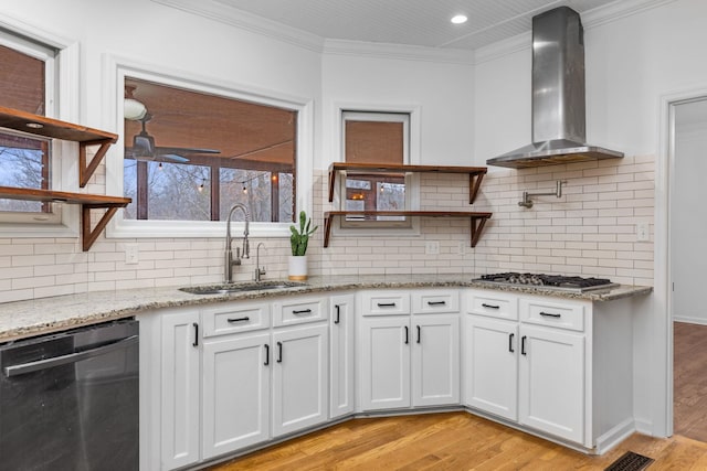 kitchen featuring stainless steel gas stovetop, white cabinetry, dishwasher, sink, and wall chimney exhaust hood