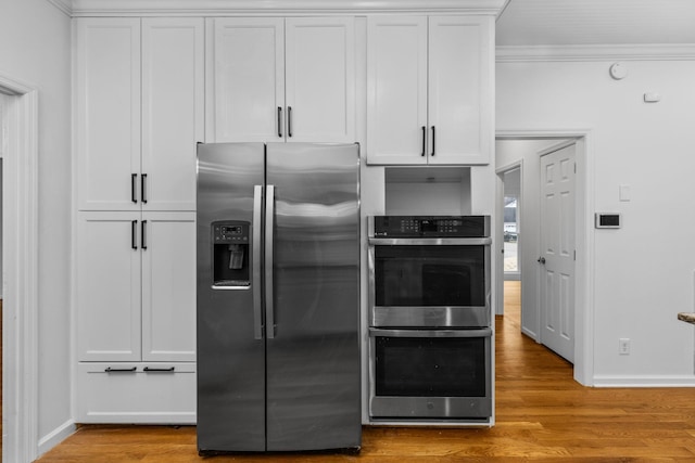 kitchen with white cabinetry, light hardwood / wood-style flooring, ornamental molding, and appliances with stainless steel finishes