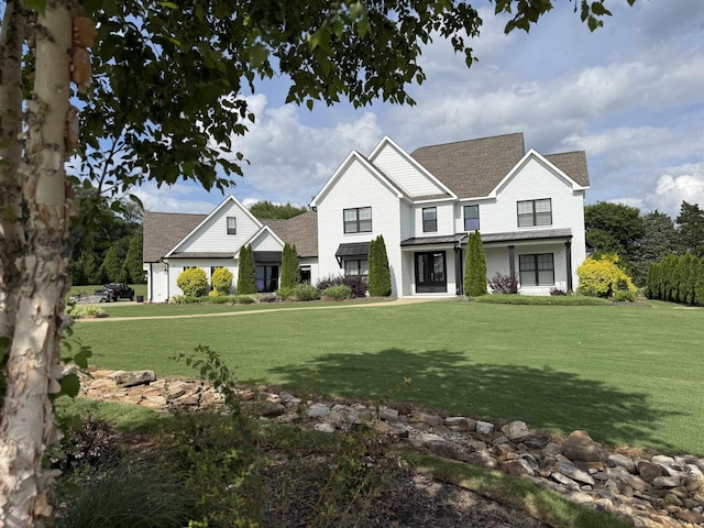  - view of front of home featuring a front yard and roof with shingles