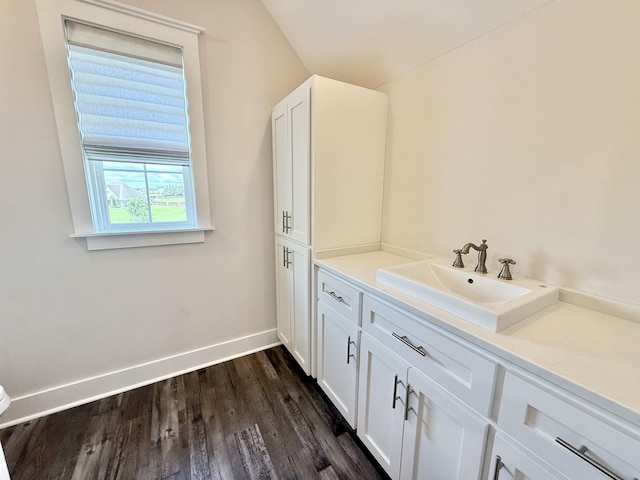  - bathroom featuring vanity, baseboards, and wood finished floors